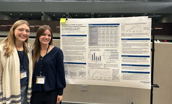 Two smiling women standing next to SRFC research poster